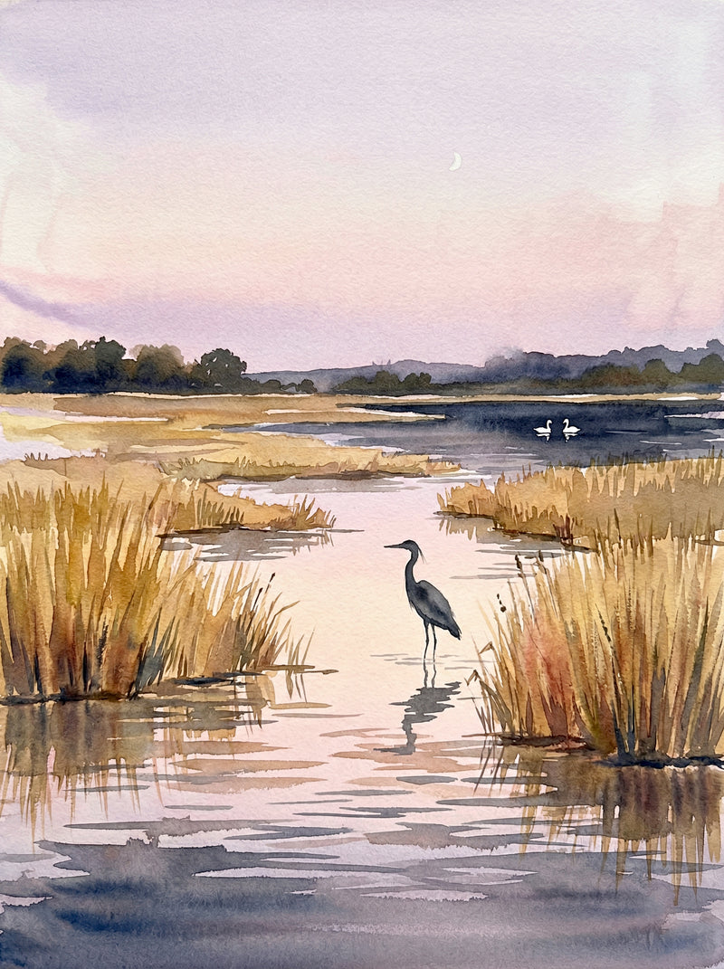A grey heron standing motionless in British wetland shallows at dusk with reed beds and a pale pink and lilac evening sky, watercolour fine art print