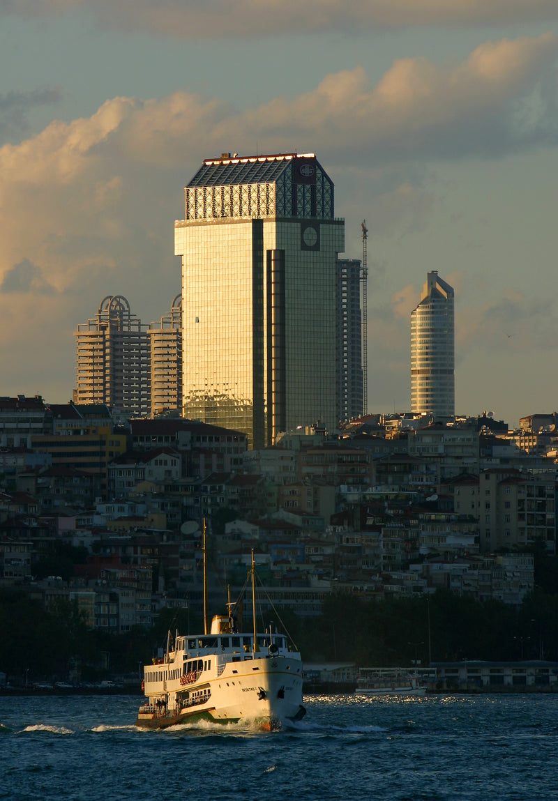 Istanbul modern skyline with glass skyscrapers and a white Bosphorus ferry at golden hour, fine art photography print