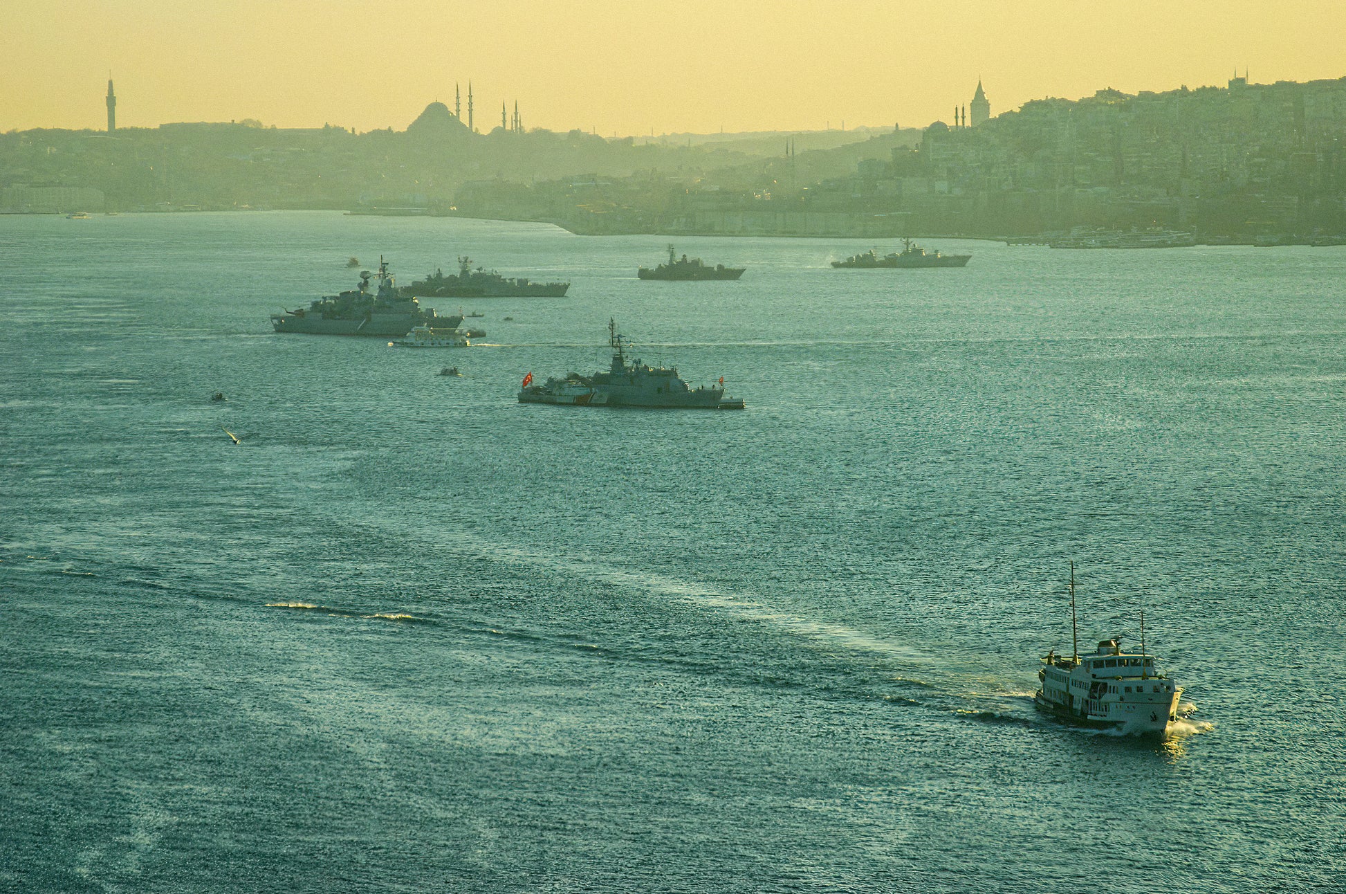 A lone vessel crossing a hazy Bosphorus with Istanbul's misty skyline of minarets and rooftops dissolving in the distance, fine art photography print
